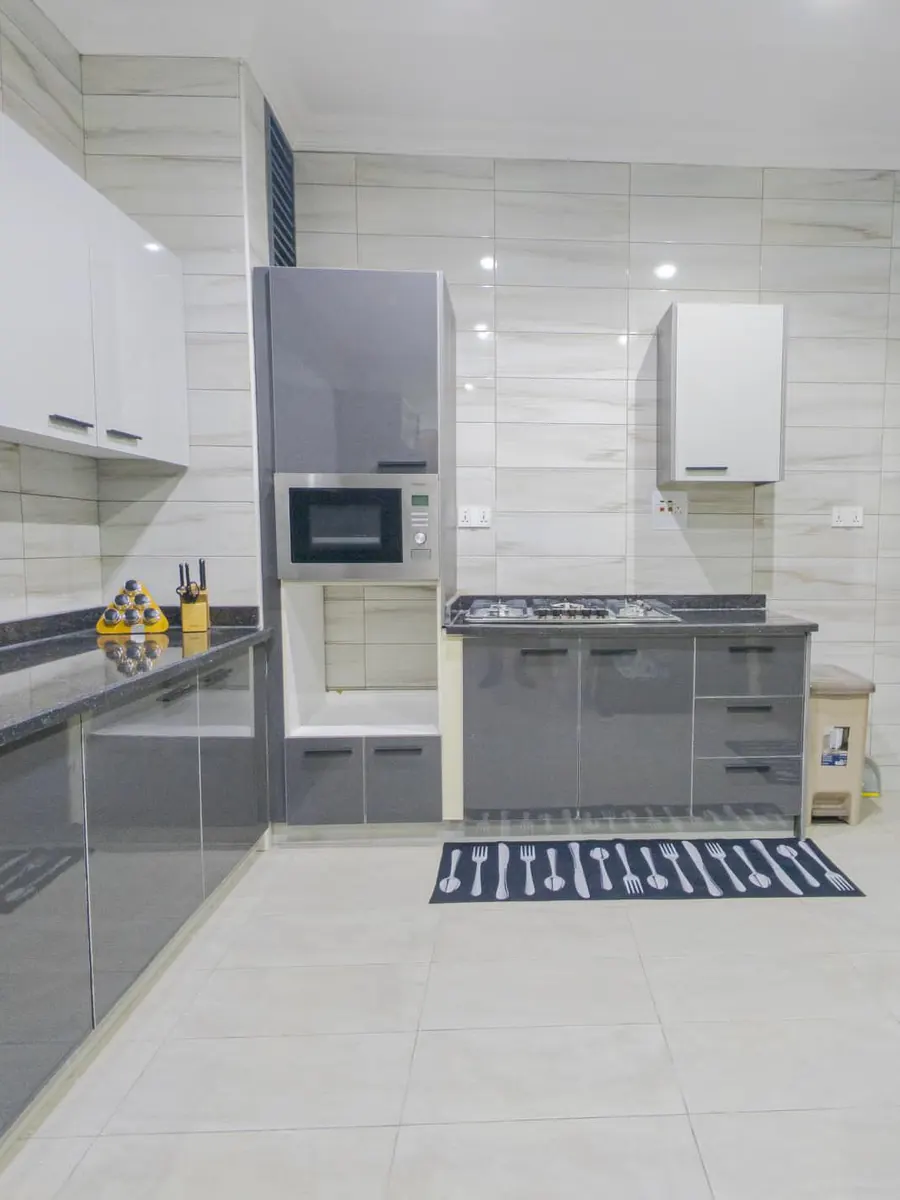 Modern fitted kitchen with gloss cabinets, built-in microwave and gas hob